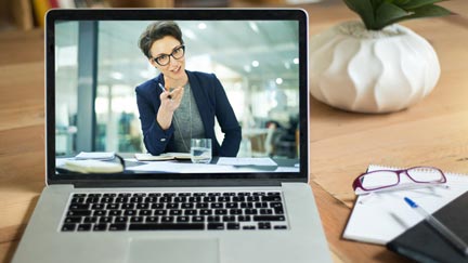 A laptop plays a video recording of a business woman