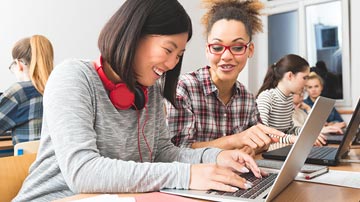 Deux étudiants universitaires regardant une rediffusion d'une conférence gratuite